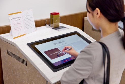 フロント型チェックイン機 NBS32 を操作する様子